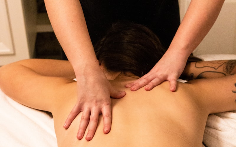 A therapist working across a client's shoulders during a full body massage