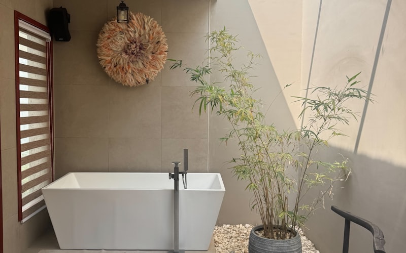A calm, plant-filled spa bathroom with a freestanding tub